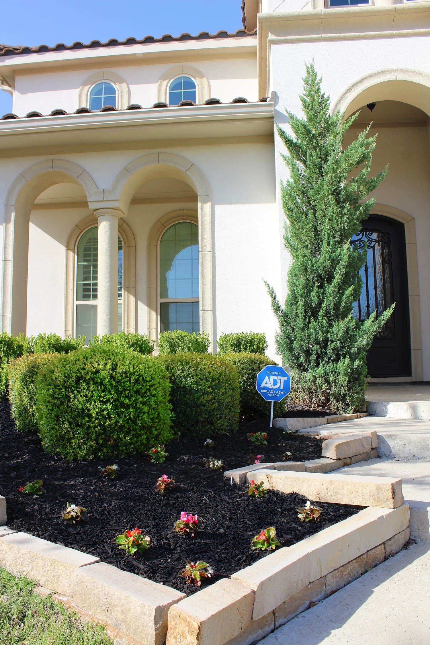 Shaped hedges and a cypress line framing a front entry
